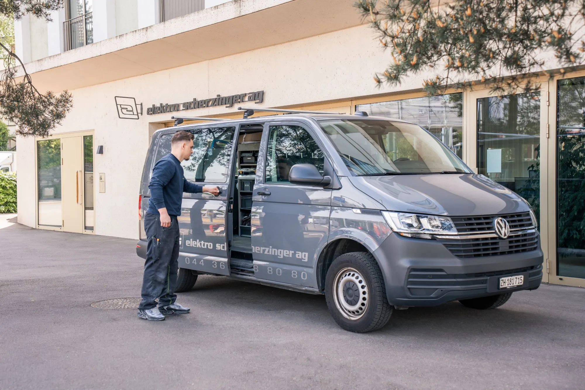 Elektriker öffnet den Servicewagen von Elektro Scherzinger vor dem Firmensitz in Zürich
