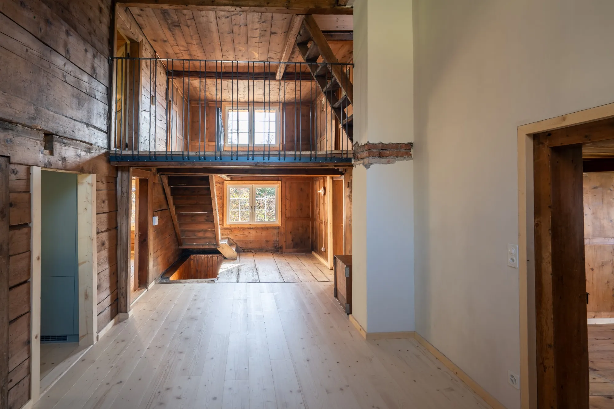 Heller Wohnraum mit neuem Holzboden, alten Strickwänden und Galerie