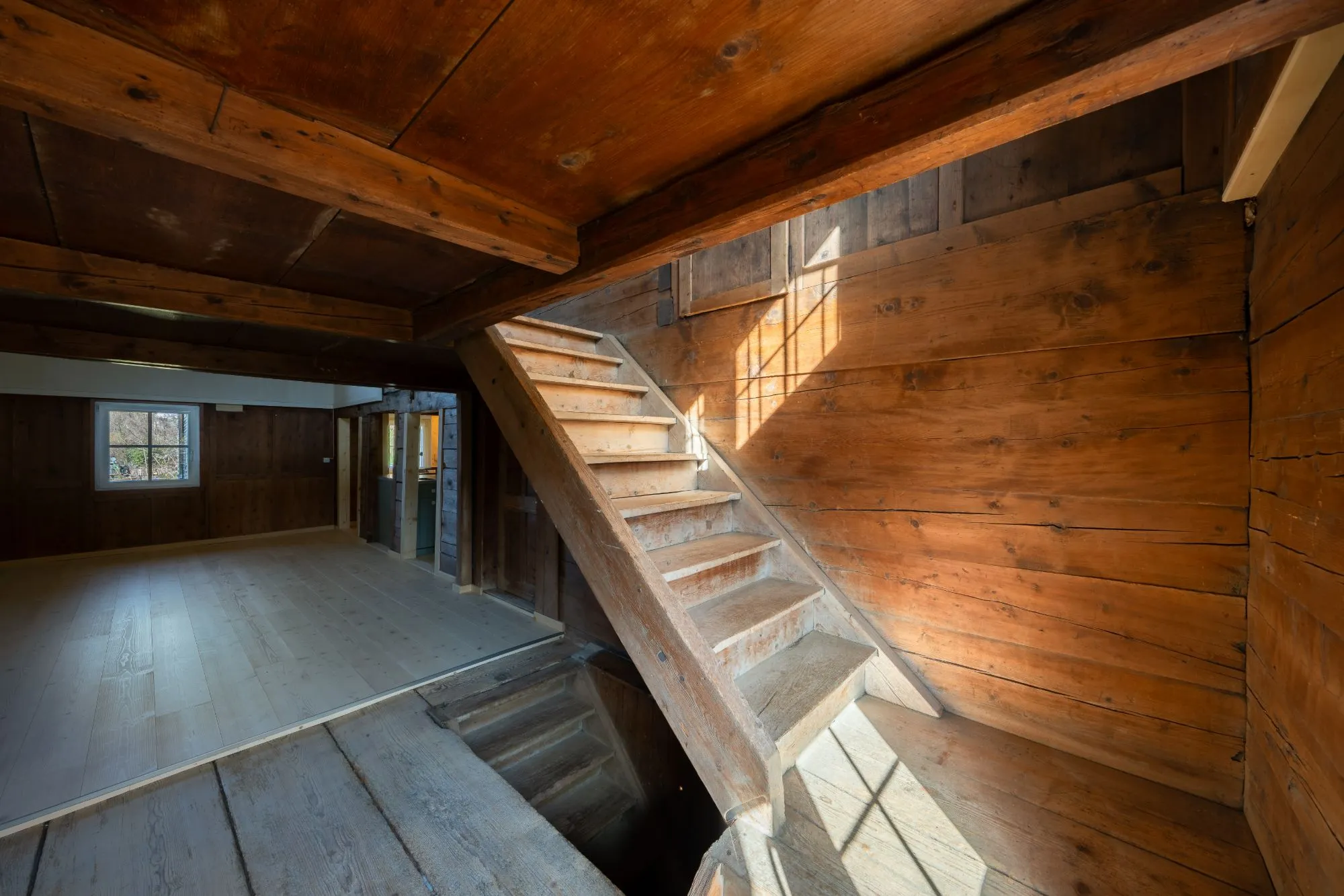 Alte Holzstiege vor einer Strickwand im Streiflicht